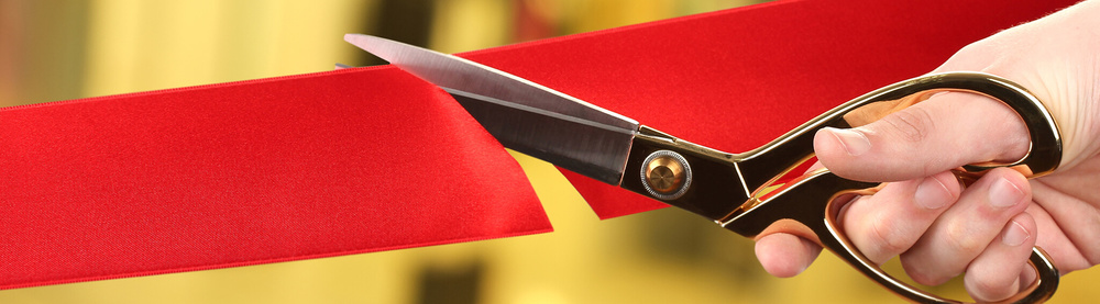 red ribbon cut by scissor with gold background